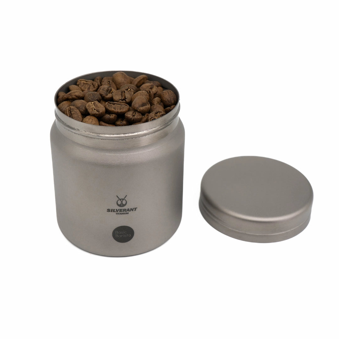 Silver titanium metal container with coffee beans on a white background Basic Barista Coffee Gear Logo Etched Coffee Bean Storage container 