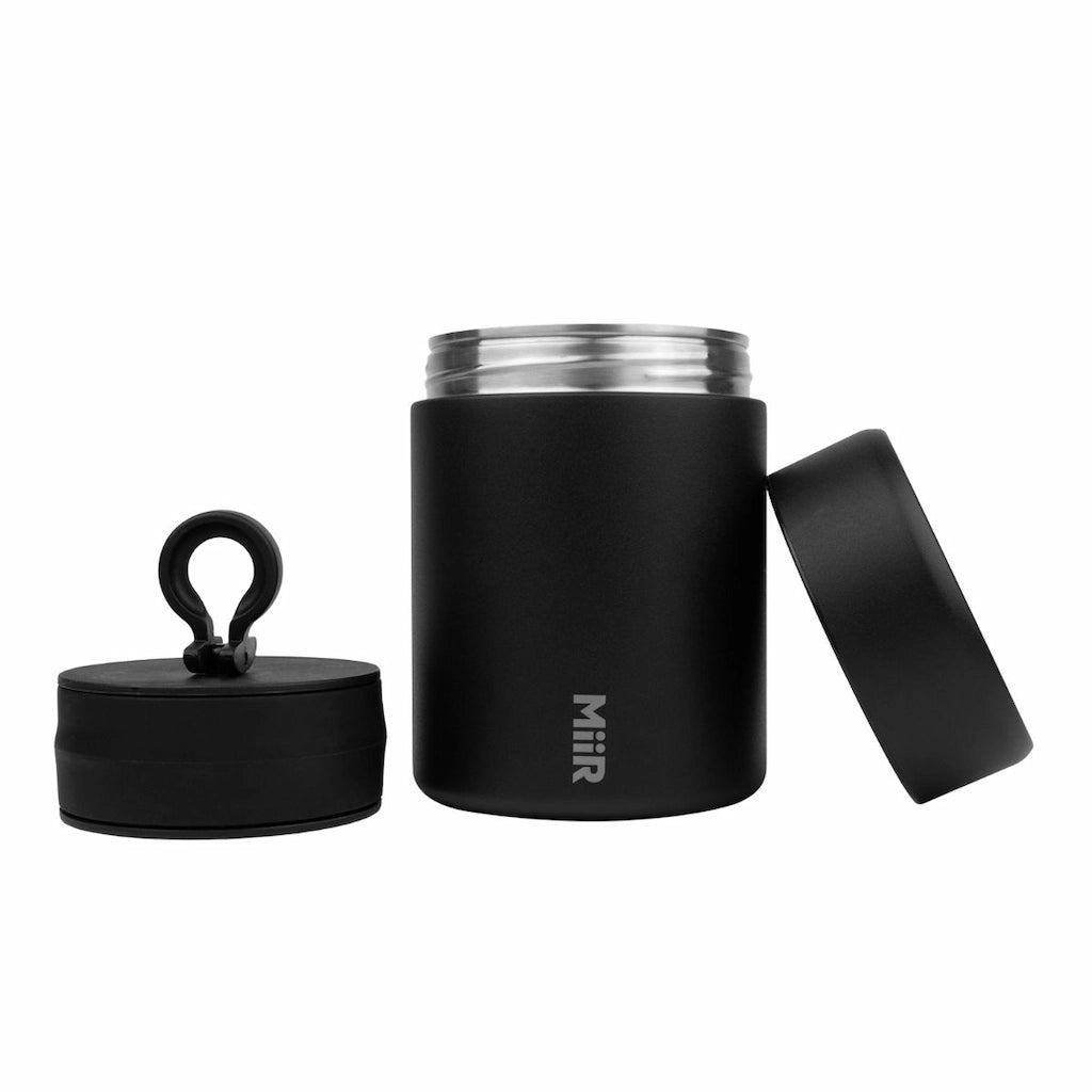 Black insulated coffee bean jar with multiple lids on a white background